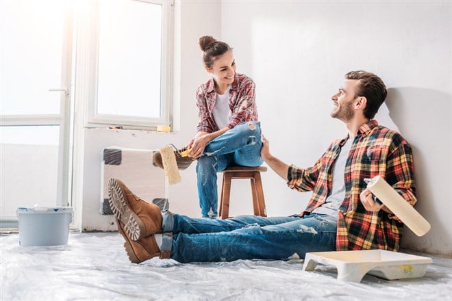 Young couple renovating a home; learn more about home improvement stocks to invest in with MarketBeat